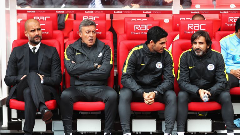 STOKE ON TRENT, ENGLAND - AUGUST 20: (L/R) Josep Guardiola, Manager of Manchester City, Domenec Torrent, Mikel Arteta and Lorenzo Buenaventura on the bench