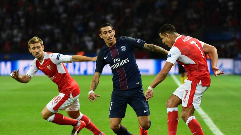Paris Saint-Germain midfielder Angel Di Maria (C) vies with Arsenal duo Nacho Monreal (L) and Alexis Sanchez (R)