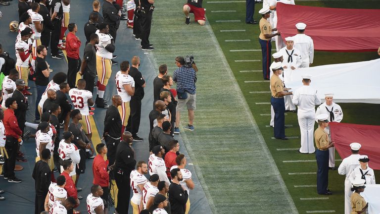 Colin Kaepernick #7 of the San Francisco 49ers takes a knee on the sidelines during the US national anthem