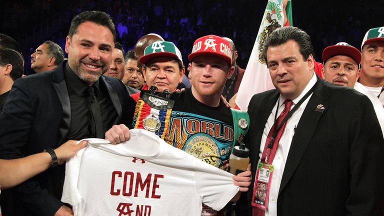 Oscar De La Hoya (L) poses with Saul Alvarez (C)