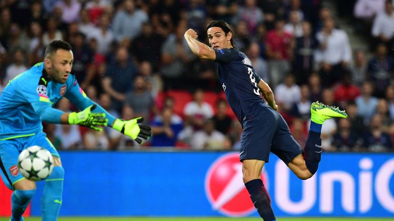 Paris Saint-Germain's Uruguayan forward Edinson Cavani (R) shoots to score despite of Arsenal's Colombian goalkeeper David Ospina (L) during the UEFA Champ