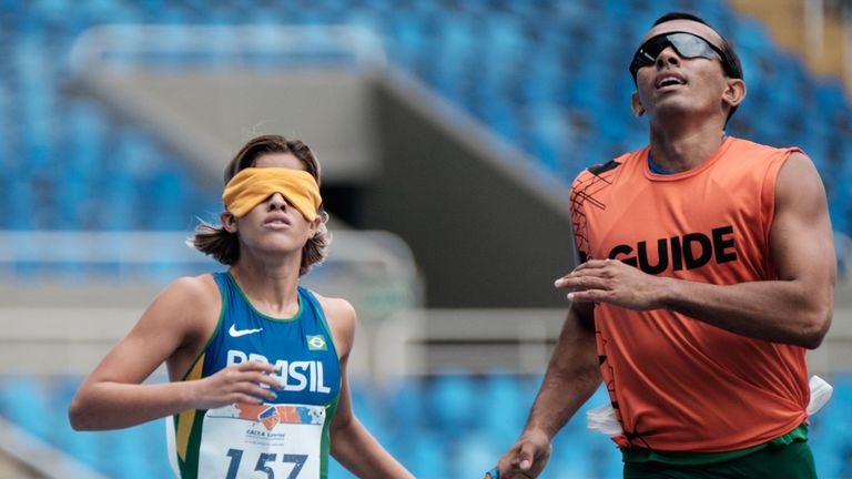 Brazil's Thalita Vitoria Simplicio da Silva (L) goals with her guide Felipe Veloso da Silva during women's 400 meter (T11) final of the Caixa Loteiras Athl