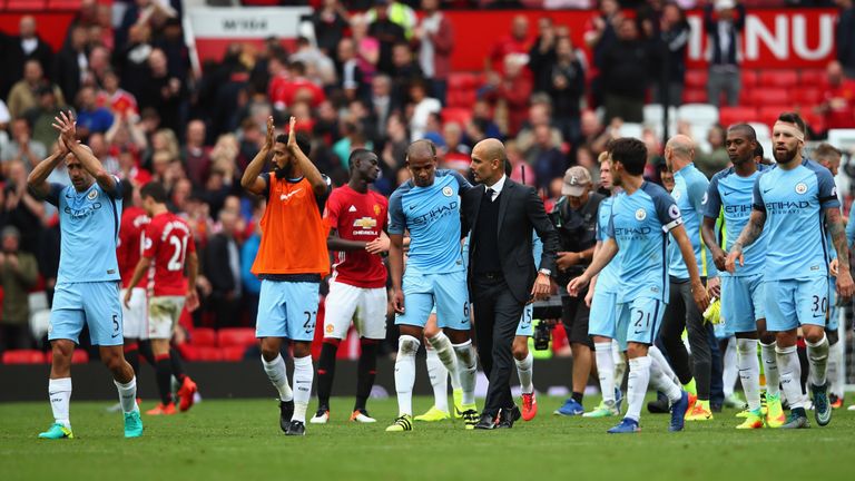 Manchester City manager Pep Guardiola celebrates with Fernando and his team after the final whistle against Manchester United