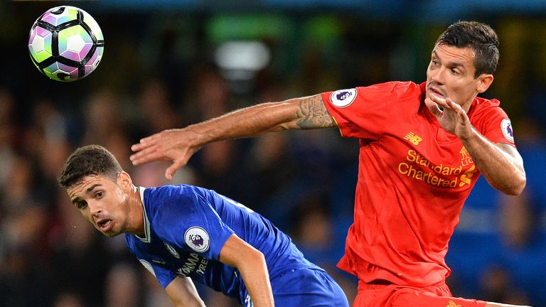 Oscar (L) and Dejan Lovren battle for possession