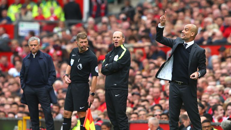 Pep Guardiola (R) reacts on the touchline at Old trafford