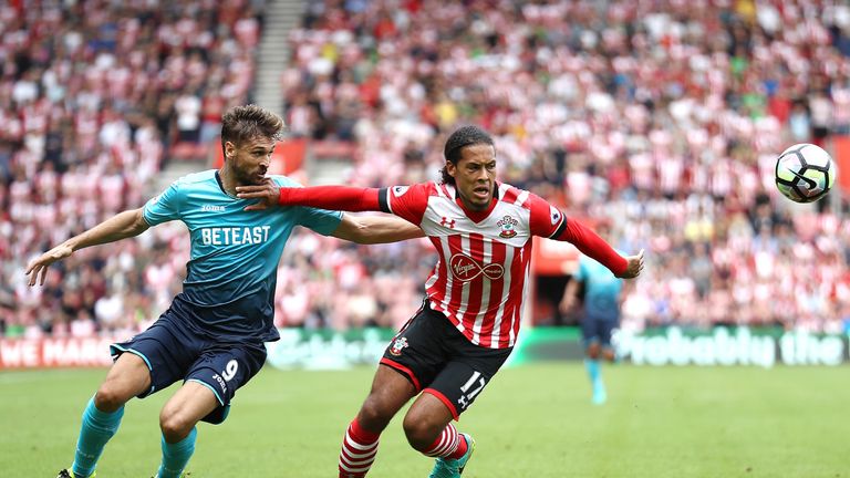 Joselu (L) and Virgil van Dijk battle for possession