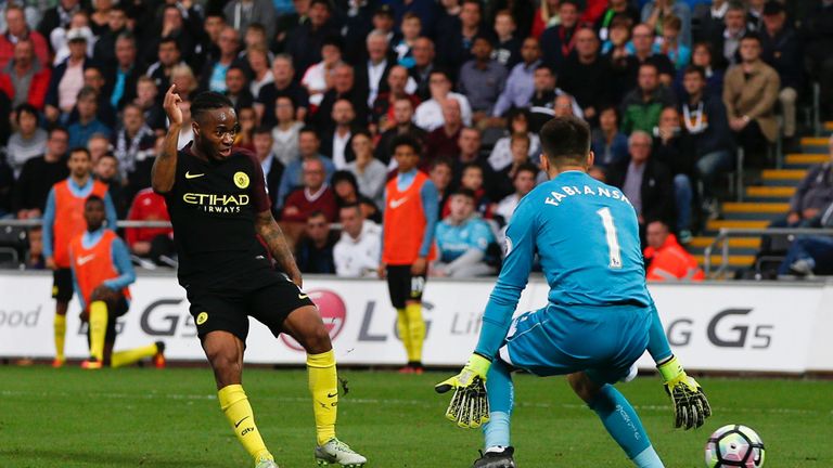 Manchester City's English midfielder Raheem Sterling (L) slots the ball past Swansea City's Polish goalkeeper Lukasz Fabianski (R) to score their third goa