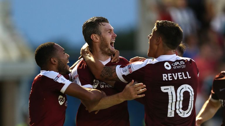 Zander Diamond of Northampton Town celebrates with team mates Alex Revell and Kenji Gorre after scoring his sides first g