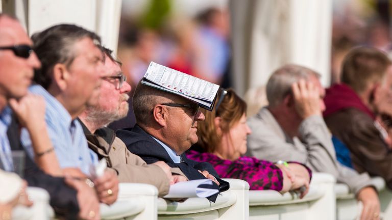Richard Fahey finds a good way to shelter from the sun during day one of the 2016 William Hill Ayr Gold Cup Festival at Ayr Racecourse.