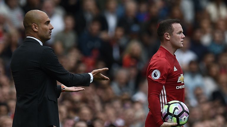 Manchester United's English striker Wayne Rooney (R) and Manchester City's Spanish manager Pep Guardiola clash on the touchline as Rooney retrieves the bal