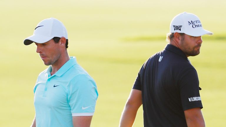 Rory McIlroy of Northern Ireland (L) and Ryan Moore wait on the 18th green during the final round of the TOUR Championship 