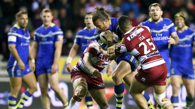 Ashton Sims is tackled by Wigan's Tony Clubb (left) and Willie Isa