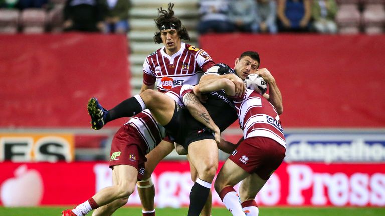 Mark Minichello is tackled by Wigan's John Bateman and Matty Smith