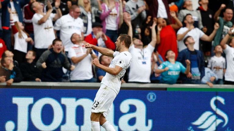 Swansea City's Icelandic midfielder Gylfi Sigurdsson celebrates in front of their supporters after scoring their first goal from the penalty spot during th
