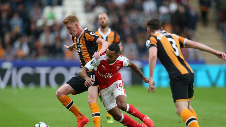 Sam Clucas of Hull City holds off Theo Walcott of Arsenal (C) during the Premier League match at the KCOM stadium