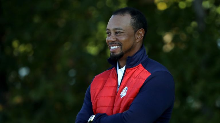 Tiger Woods sees the funny side after being ushered away from the team photo