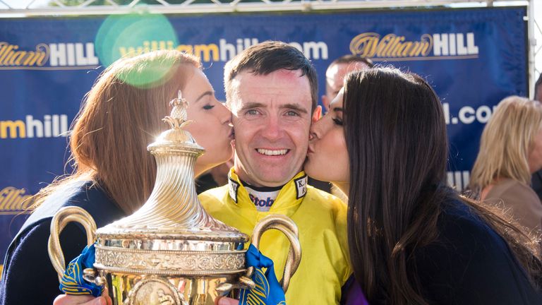 Jockey Tom Eaves celebrates winning the William Hill Ayr Gold Cup on Brando, presented to him by Miss Scotland, Lucy Kerr, and Mhairi Fergusson.