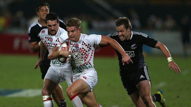 Tom Mitchell of England (C) is tackled by Tim Mikkelson of New Zealand during the Dubai Sevens Third place matc
