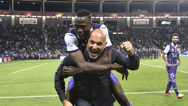 Toulouse defender Issiaga Sylla  celebrates with head coach Pascal Dupraz after beating PSG