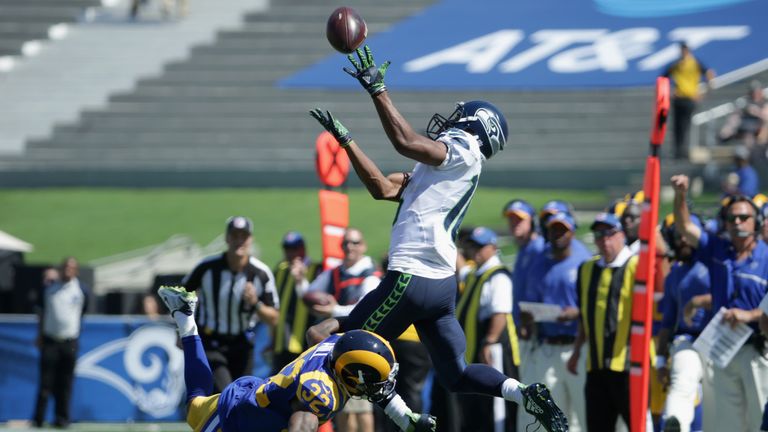 LOS ANGELES, CA - SEPTEMBER 18:  Tyler Lockett #16 of the Seattle Seahawks reaches up to make the catch over Troy Hill #32 of the Los Angeles Rams during t