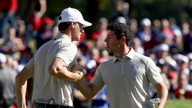 Thomas Pieters and Rory McIlroy after a birdie putt goes in at 15