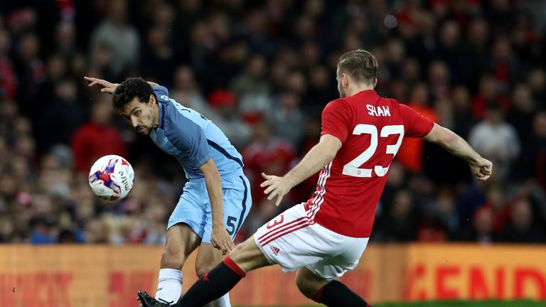 Jesus Navas of Manchester City (L) crosses the ball while Luke Shaw of Manchester United (R) attempts to block during the EFL Cup tie