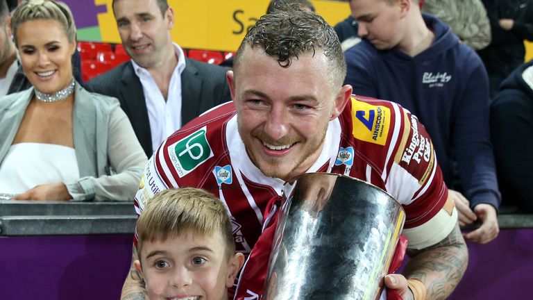 Wigan's Josh Charnley poses for photos with the trophy and young fan Jack Johnson after winning the Super League Grand Final