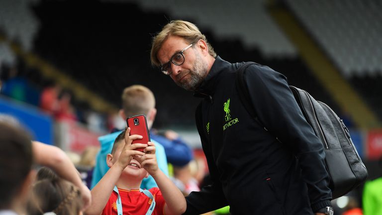 Jurgen Klopp stops for a selfie with a fan ahead of Liverpool's game at Swansea