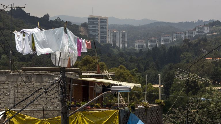 General view of houses constructed over ravines in a poor zone behind rich housing developments in Mexico City , on July 24, 2012. AFP PHOTO/OMAR TORRES   