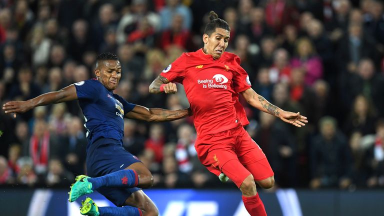 Antonio Valencia makes a tackle on Roberto Firmino during the match between Liverpool and Manchester United at Anfield