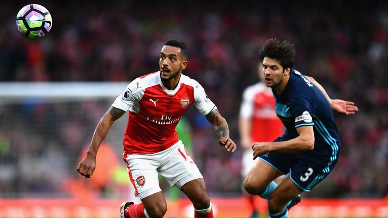 LONDON, ENGLAND - OCTOBER 22: Theo Walcott of Arsenal (L) watches the ball while George Friend of Middlesbrough (R) attempts to chase him down during the P