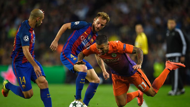 Ivan Rakitic (C) and Javier Mascherano (L) vie with Aleksandr Kolarov