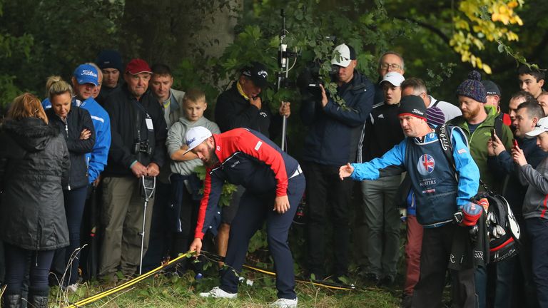 WATFORD, ENGLAND - OCTOBER 15:  Andrew Johnston of England moves cables on the first hole that are obstructing his play of the ball during the third round 