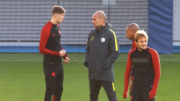 Josep Guardiola speaks with John Stones during a training session