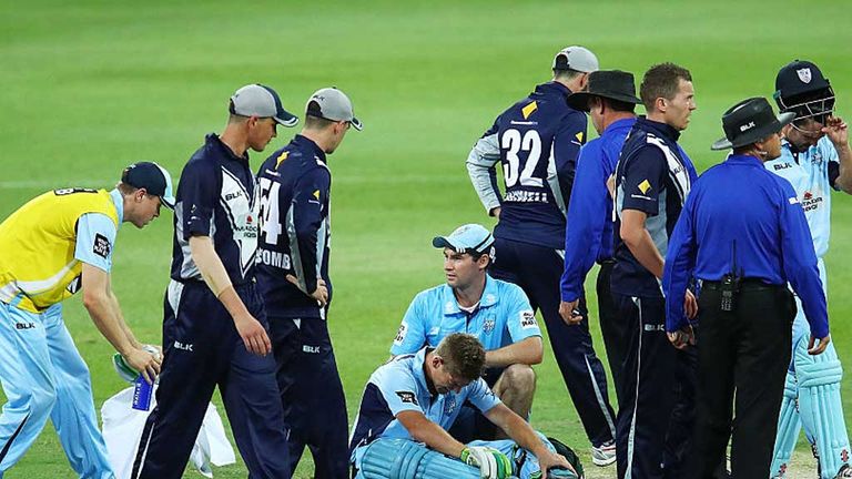 Daniel Hughes (seated) receives treatment before leaving the field of play