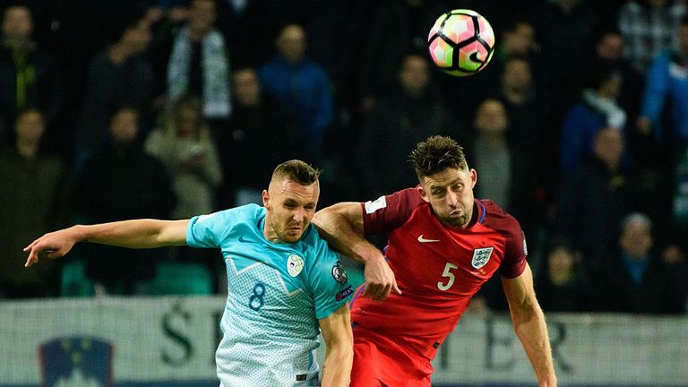 Slovenia's midfielder Jasmin Kurtic (L) vies for the ball with England's defender Gary Cahill