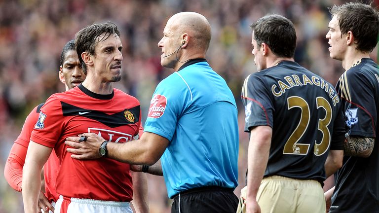 Howard Webb stands between Gary Neville and Jamie Carragher during the match at Old Trafford