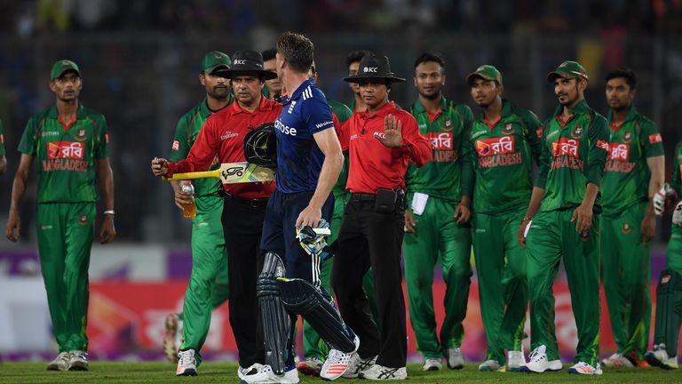 Jos Buttler leaves the field as umpires Aleem Dar and Sharfuddoula separate him from the Bangladesh fielders