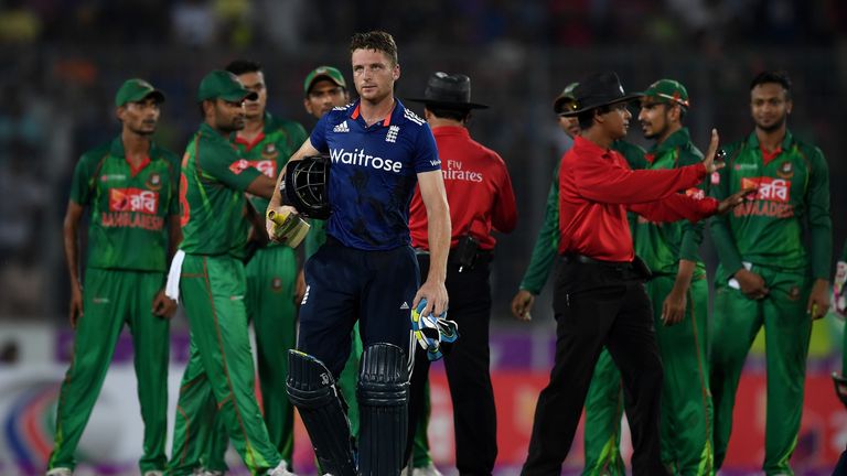 DHAKA, BANGLADESH - OCTOBER 09:  Jos Buttler leaves the field as umpires Aleem Dar and Sharfuddoula separate his from the Bangladesh fielders during the 2n
