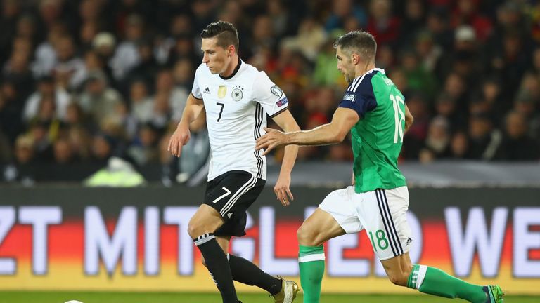 Aaron Hughes challenges Germany's Julian Draxler