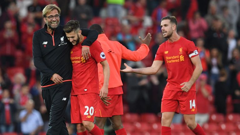 Liverpool's German manager Jurgen Klopp (L) celebrates on the pitch with Liverpool's English midfielder Adam Lallana (2nd L) after the English Premier Leag