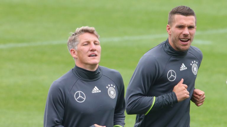 EVIAN-LES-BAINS, FRANCE - JUNE 14:  Bastian Schweinsteiger (L) of Germany runs with his team mate Lukas Podolski during a Germany training session at Ermit