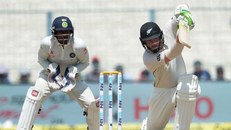 New Zealand's Martin Guptill (R) plays a shot as India's wicketkeeper Wriddhiman Saha looks on during the fourth day of the second Test match between India