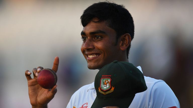 Bangladesh's Mehedi Hasan poses with the match ball and cap after his five wicket haul as he returns to the locker room after the first day of play in the 