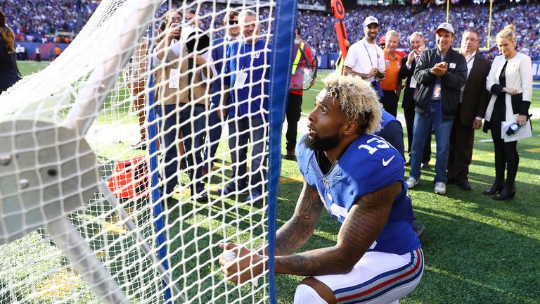 Beckham kneels in front of the kicking net after scoring a touchdown 