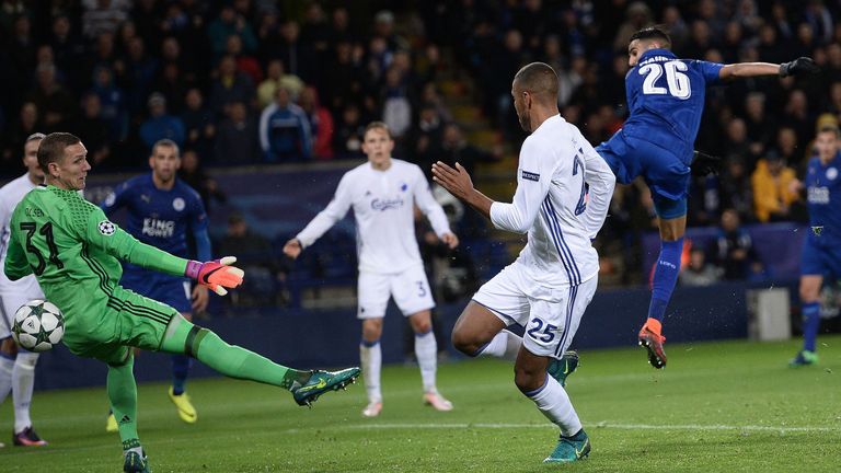 Leicester City's Algerian midfielder Riyad Mahrez (R) shoots past FC Copenhagen's Swedish goalkeeper Robin Olsen (L) to scores his team's first goal during