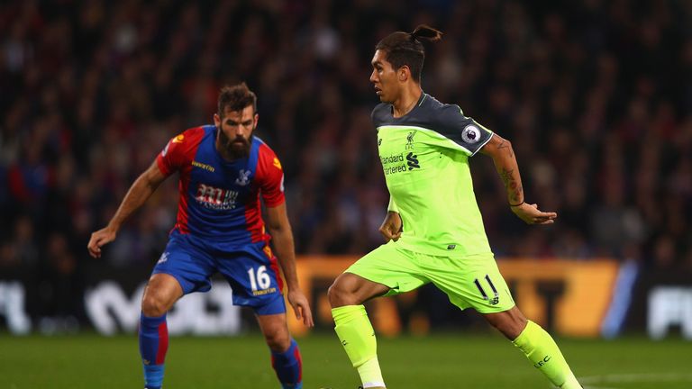 Roberto Firmino of Liverpool (R) takes the ball past Joe Ledley of Crystal Palace