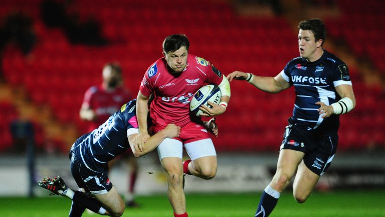 Steffan Evans of Scarlets is tackled by Mike Haley and Sam James(R) of Sale Sharks . Champions Cup 15/10/16