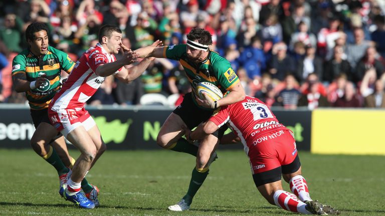 GLOUCESTER, ENGLAND - MARCH 07:  Tom Wood of Northampton is tackled by Jonny May and John Afoa (R) during the Aviva Premiership match between Gloucester an