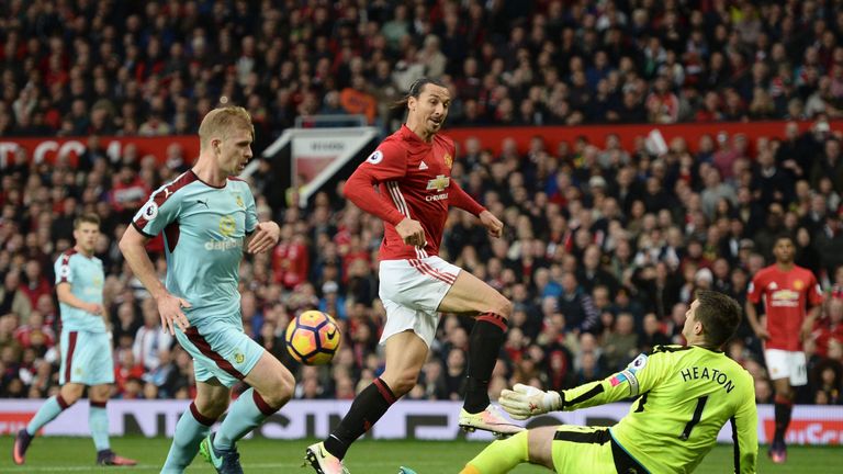 Burnley's Tom Heaton (R) saves a shot from Zlatan Ibrahimovic (C)